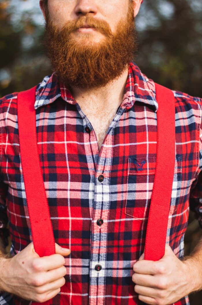 man in red, blue, and white plaid dress shirt with red suspender during daytime